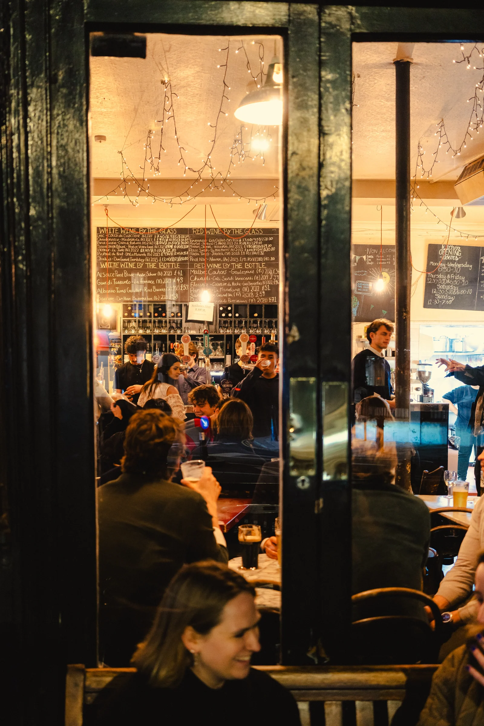 Guests gathered inside The Westbourne, seen through its window
