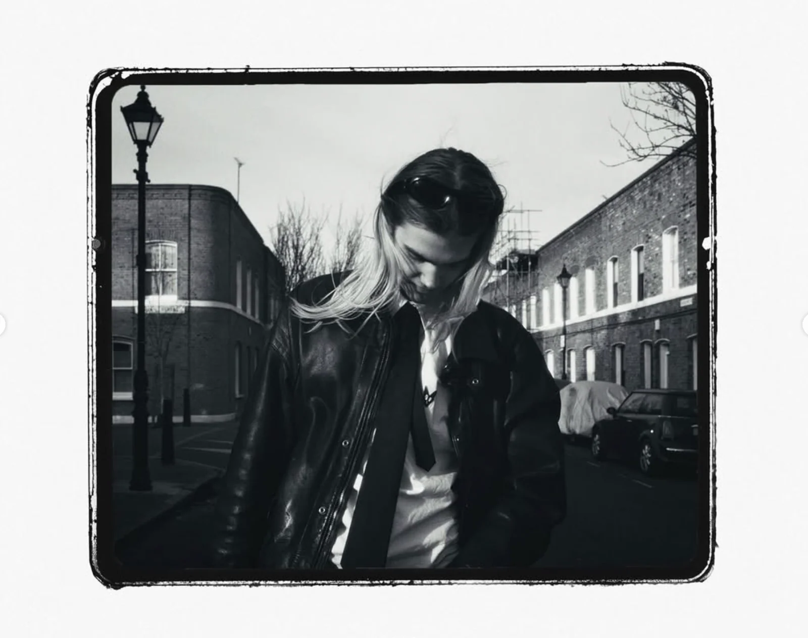 Black-and-white portrait of a man in a leather jacket on a London street