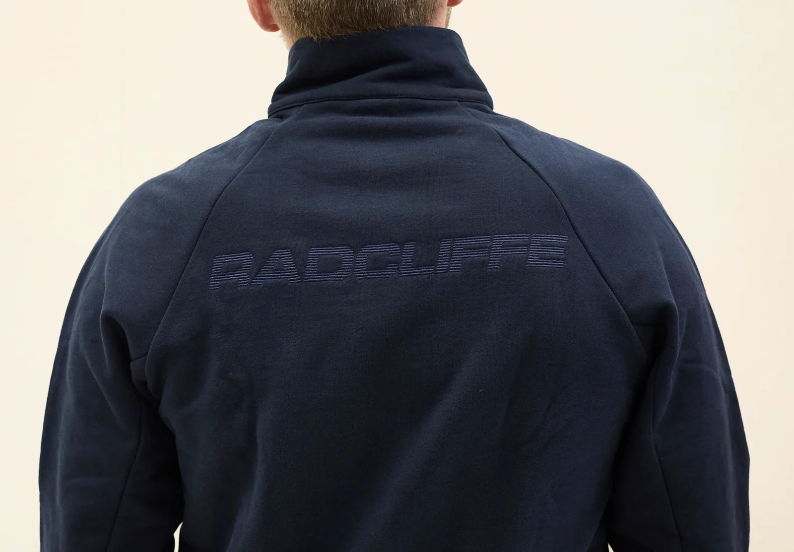 Back of a navy jacket with an embroidered Radcliffe wordmark.