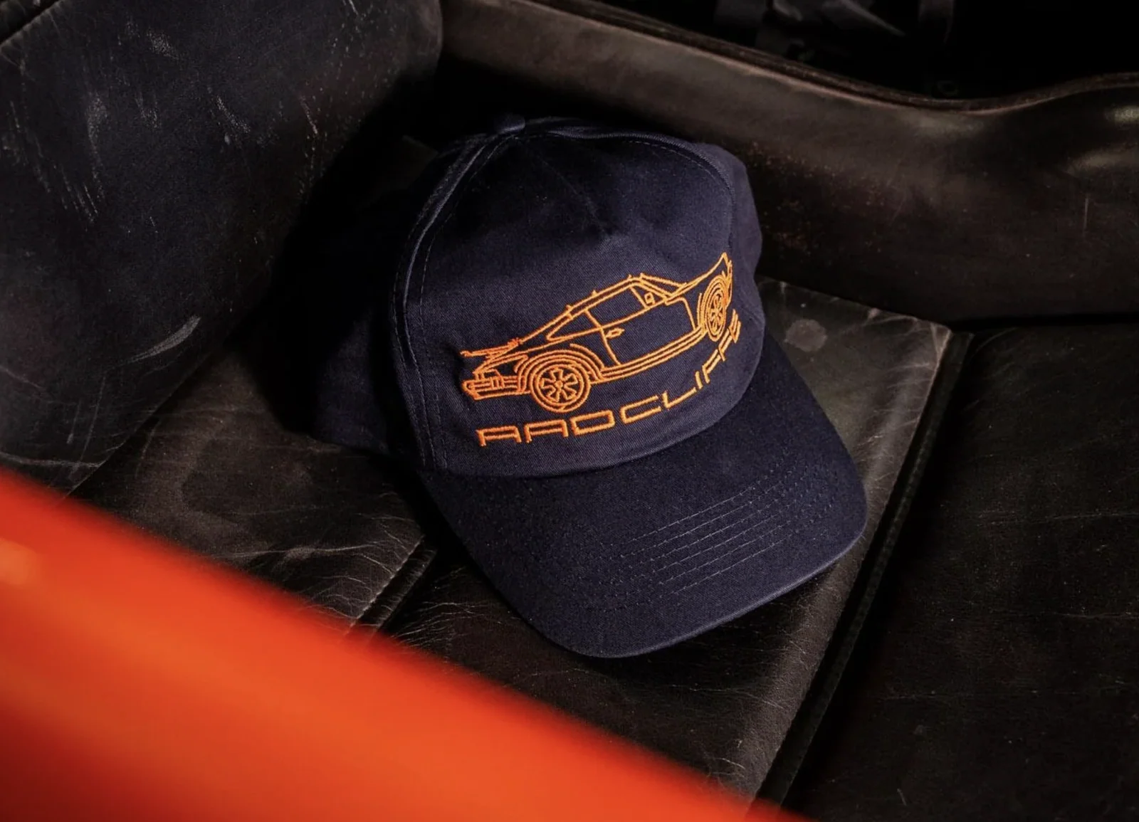 Navy cap embroidered with a yellow wireframe car and the Radcliffe name.