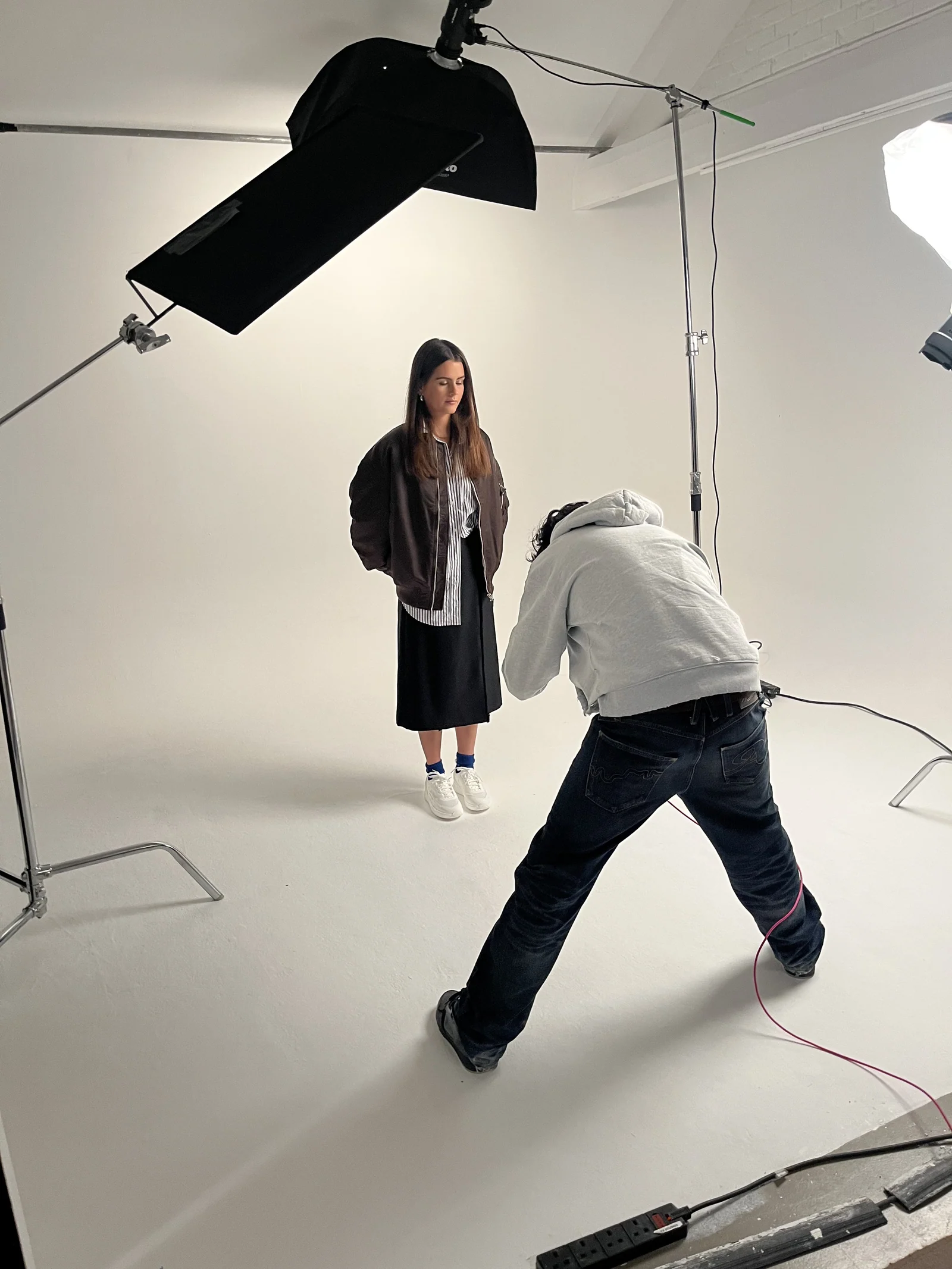 Photographer working with a model on the white studio set