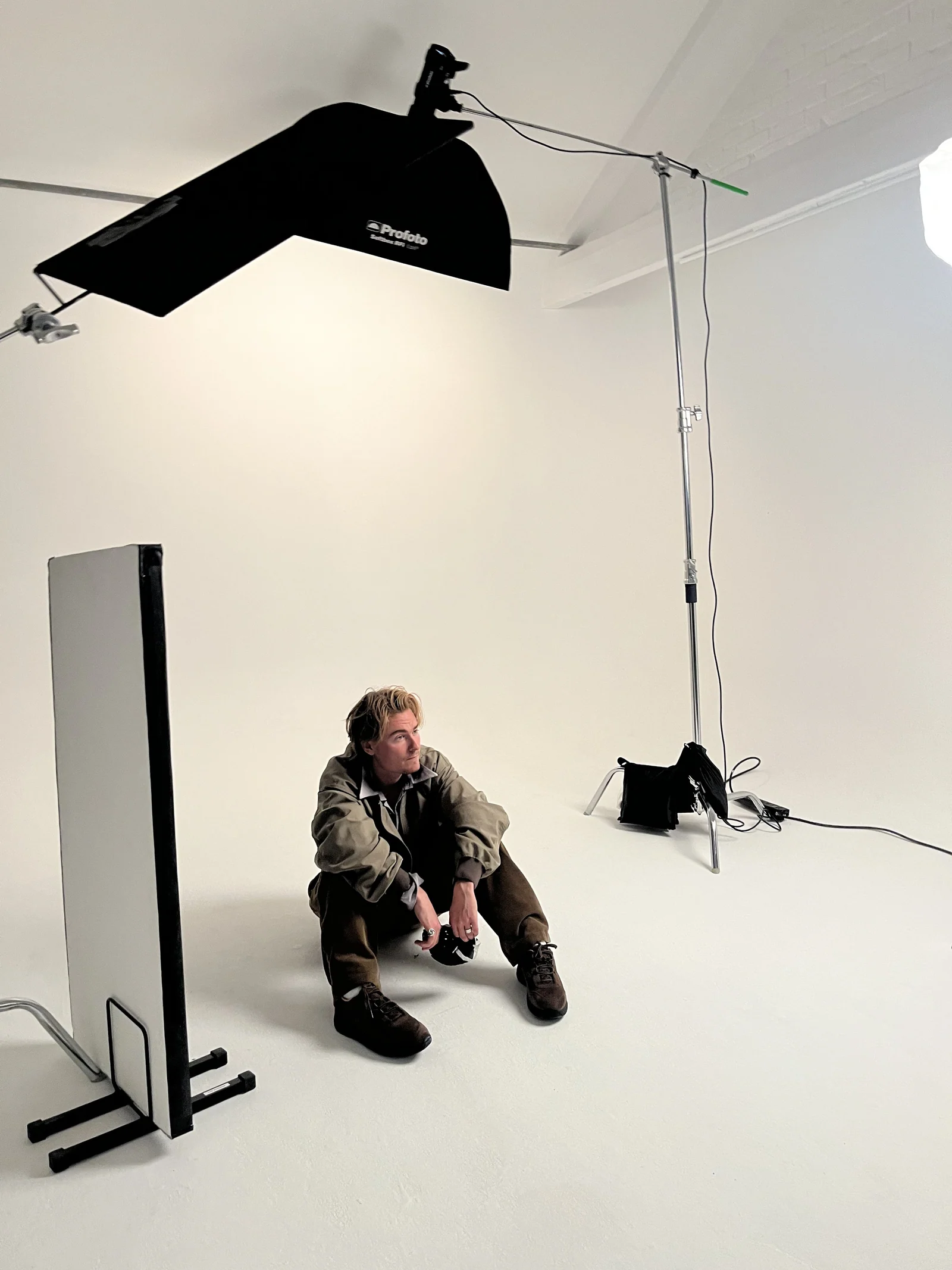 Seated model beneath the studio lighting rig