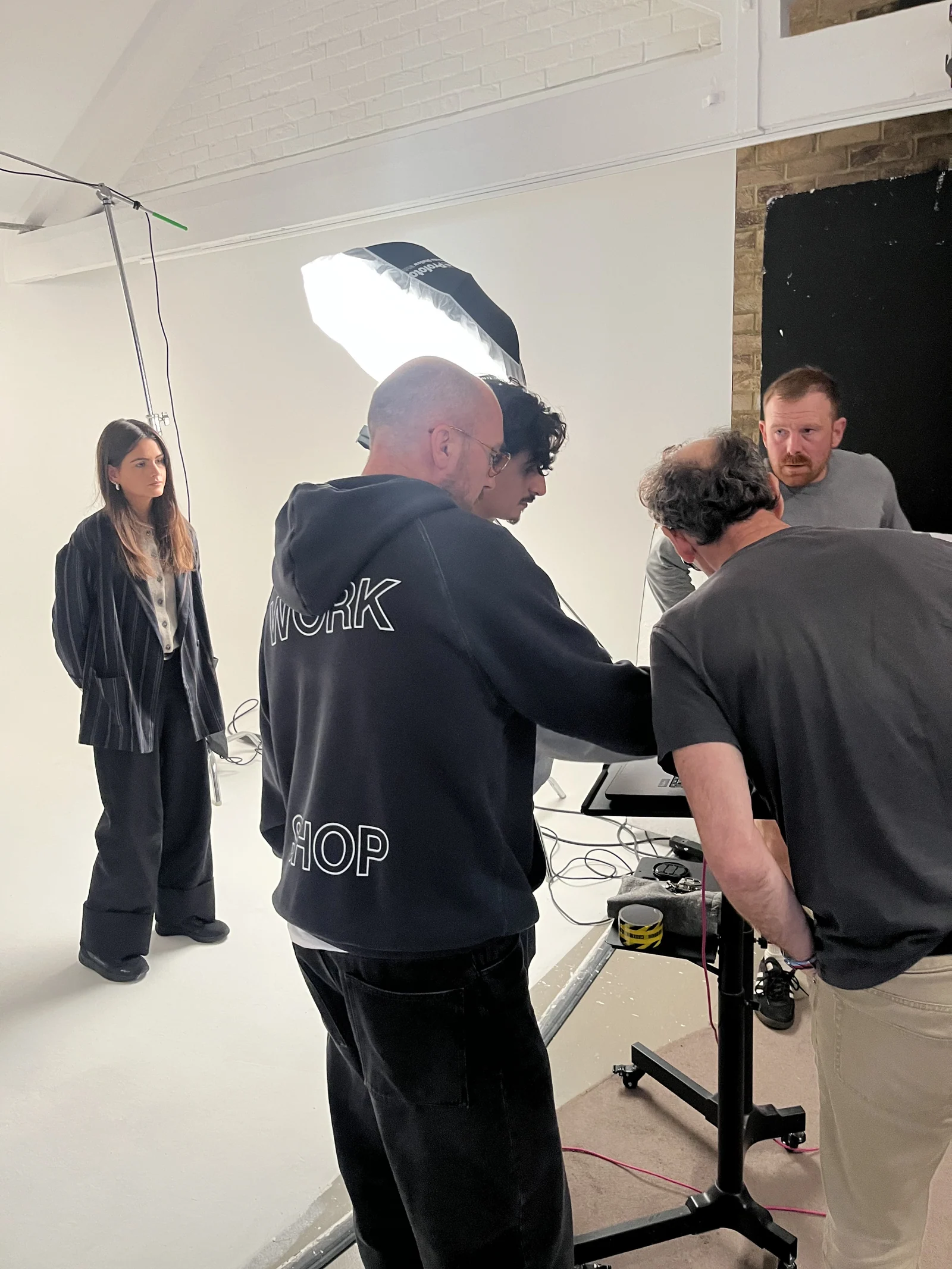Creative team reviewing the studio shoot beside a model