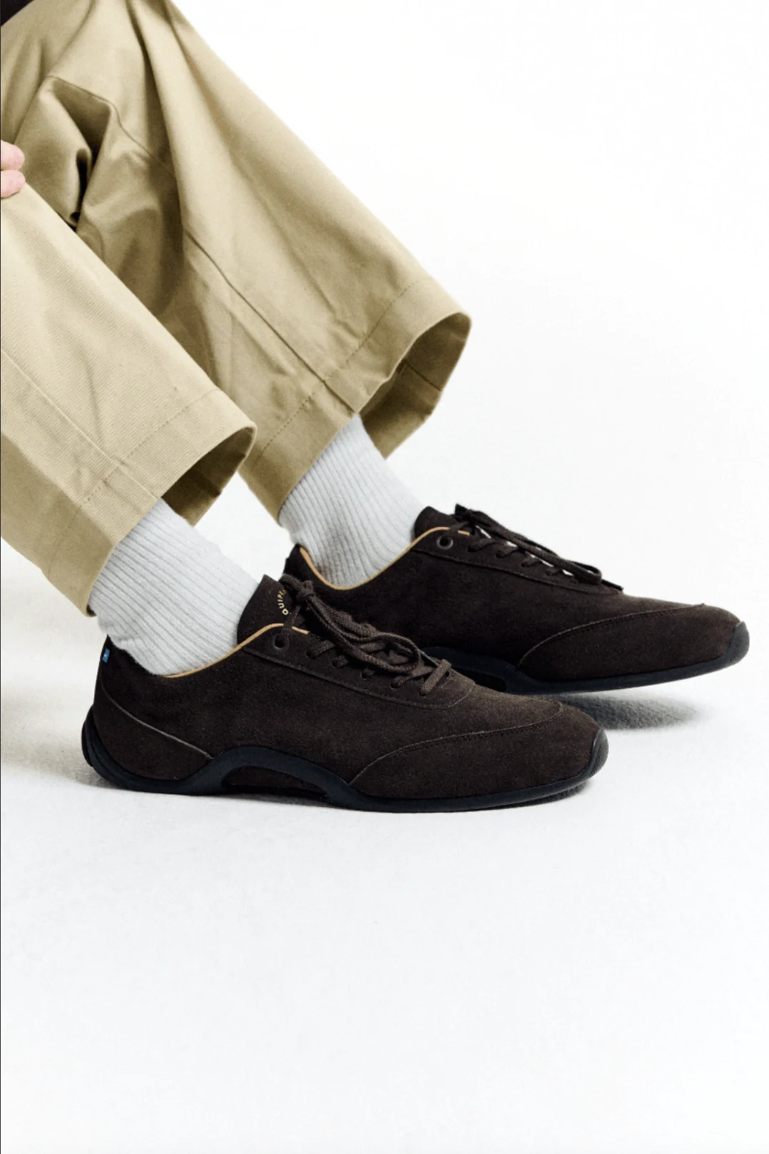 Brown suede shoes styled with pale trousers and white socks