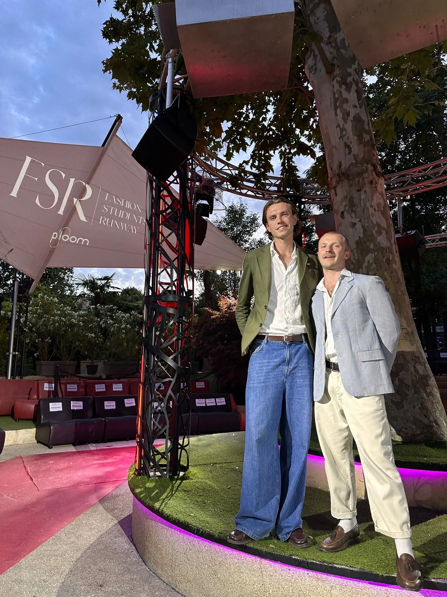 Two guests standing beside the red runway