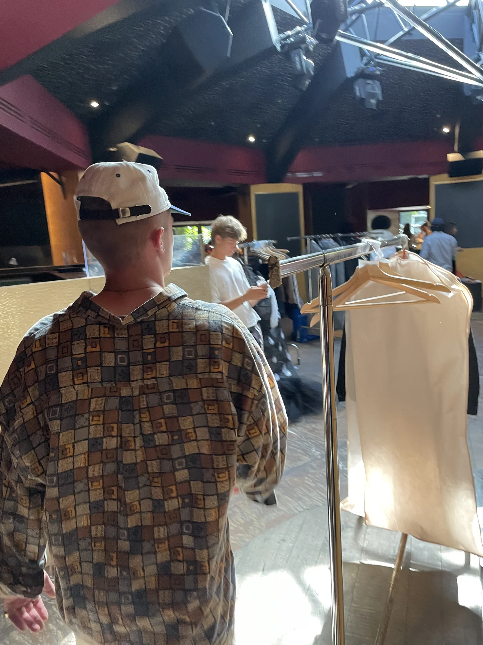Garment preparation beside the backstage clothing racks