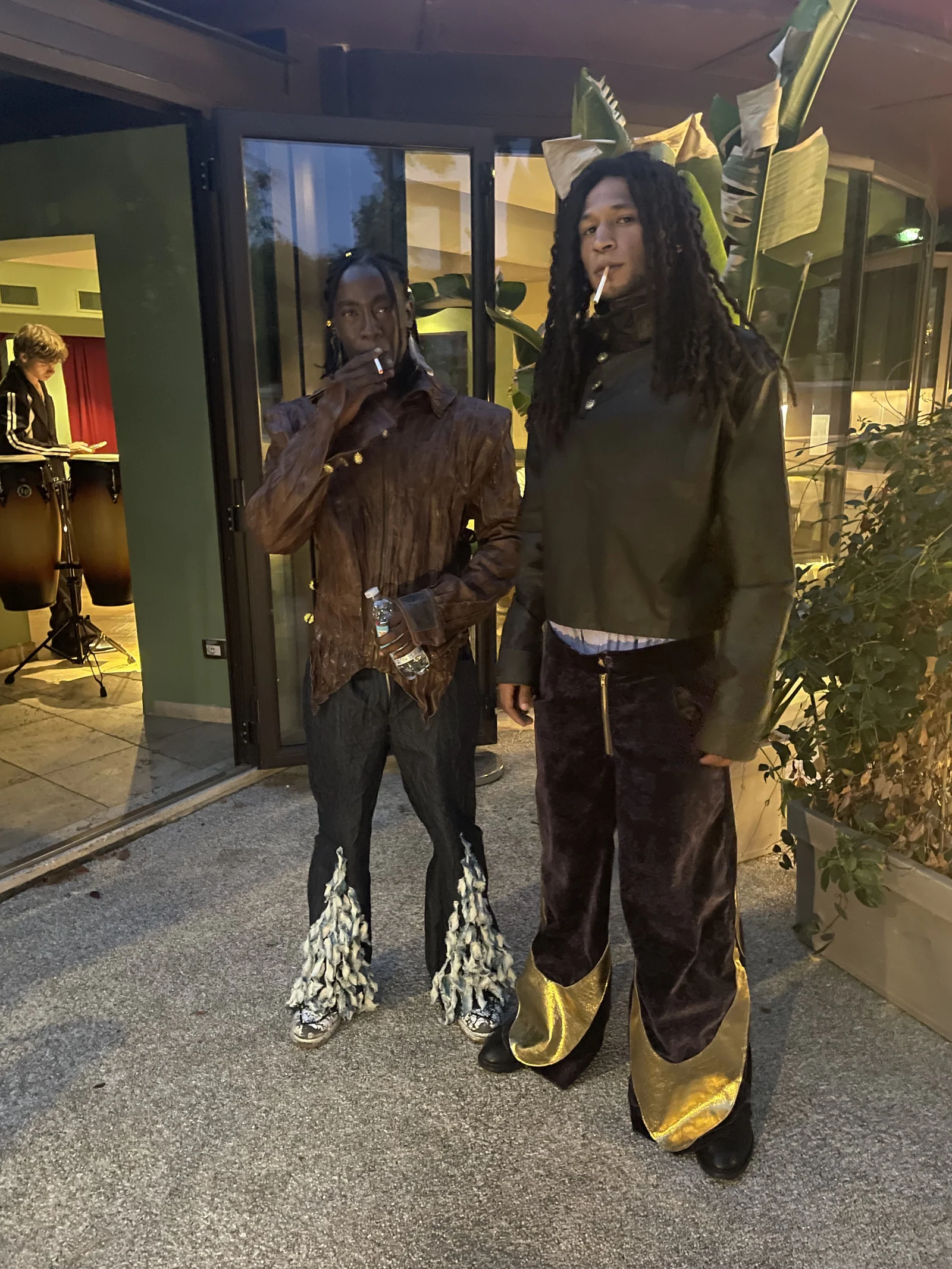 Two guests posing outside the venue in black outfits