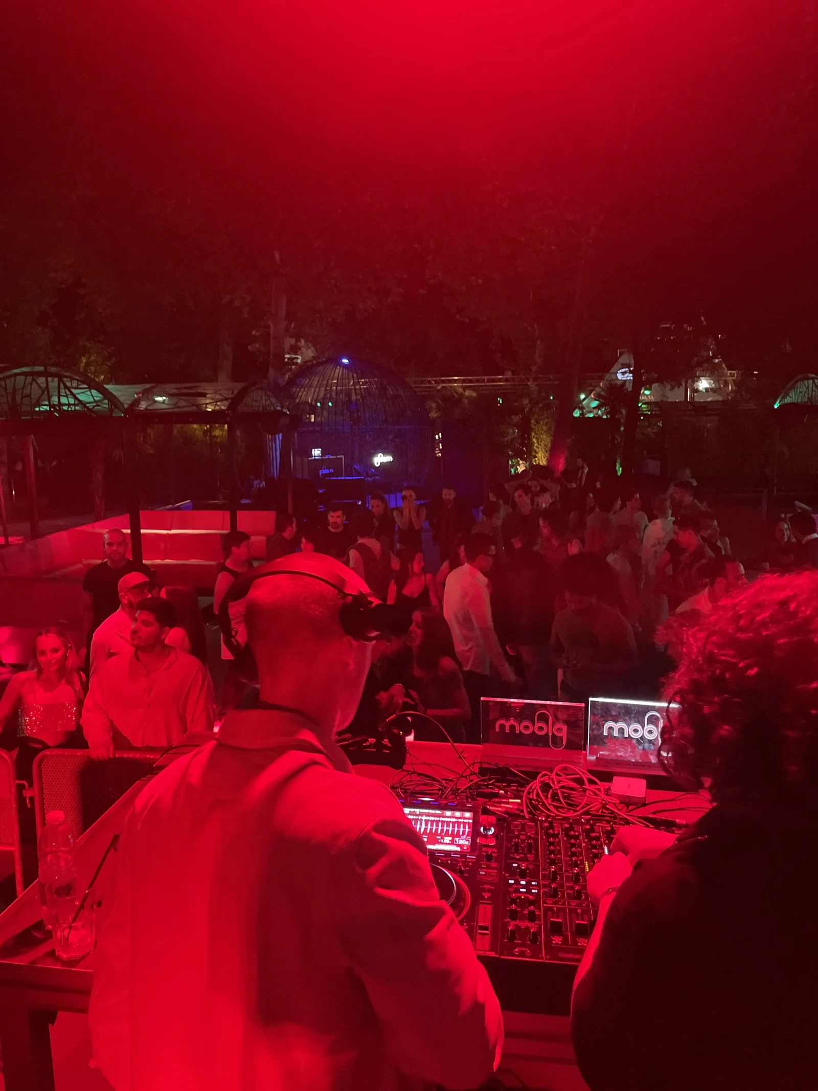Red-lit afterparty crowd and DJ booth