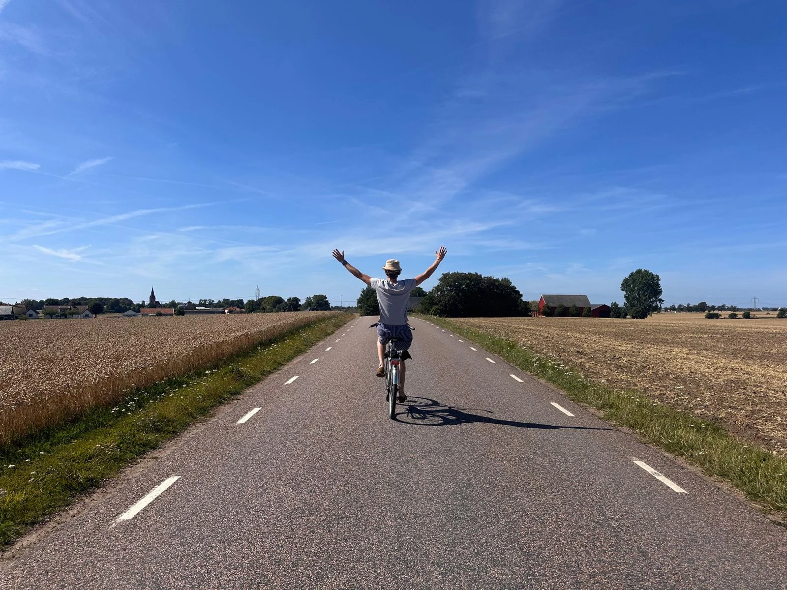 Simon Ludvigsson cycling along a country road with his arms raised